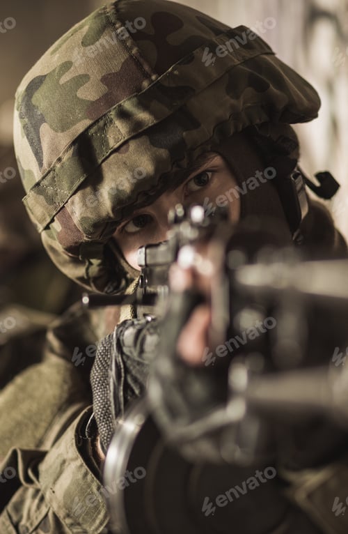 Preview: Focused Individual with Camouflage Helmet Holding a Rifle