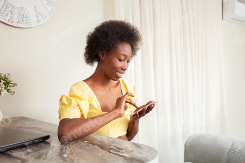 Preview: Woman Smiling Using a Mobile Phone at Home