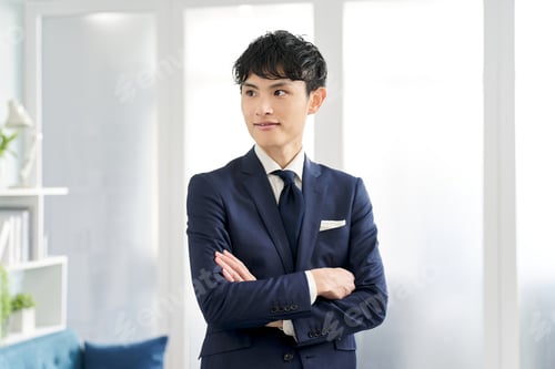 Preview: A businessman wearing a custom suit and folding his arms