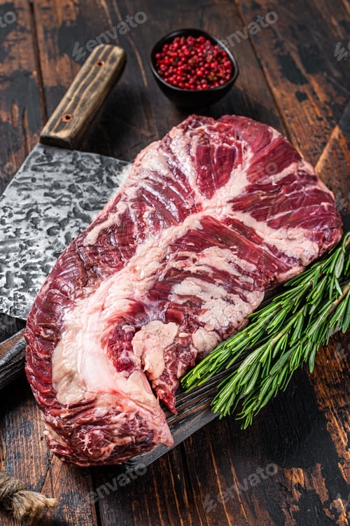 Preview: Hanging tender or hanger raw beef meat steak on butcher board with cleaver.