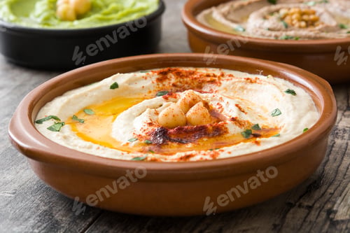 Preview: Delicious hummus seasoned with paprika, olive oil and chickpeas in ceramic bowl