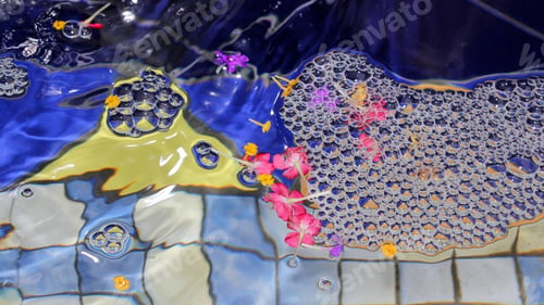 Preview: A Colorful Water Fountain Pool With Bubbles, Flowers And Coins On The Bottom.