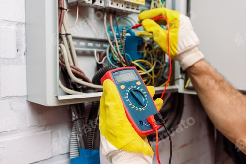 Preview: Cropped view of workman in gloves using multimeter while checking voltage of electric panel