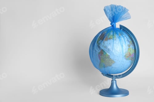 Preview: Globe in plastic bag on white background, space for text. Environmental conservation
