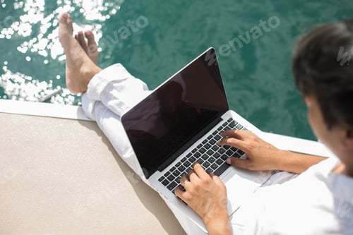 Preview: Businessman working with computer on a boat, nice outdoor office