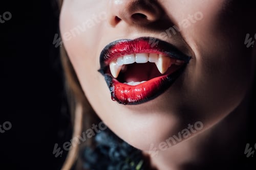 Preview: close up view of scary vampire girl with fangs isolated on black