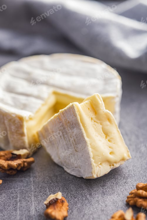 Preview: Brie type cheese with white mold. French camembert cheese on kitchen table.