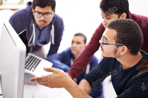 Preview: Collaborative coding. Shot of a group of colleagues working together with a computer in an office.