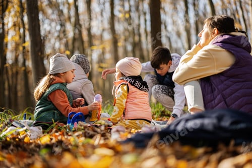 Preview: Mother with kids in family picnic at autumn forest.