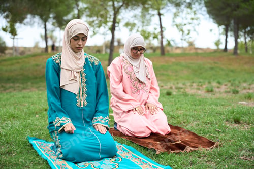 Preview: Muslim women praying salah outdoors on prayer mats