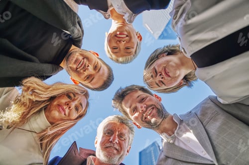 Preview: Portrait close up bottom view happy faces of diverse employees team standing in circle