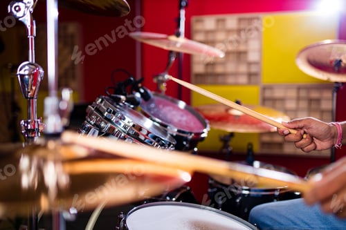 Preview: Attractive Teenage Drummer with Drumsticks in recording studio