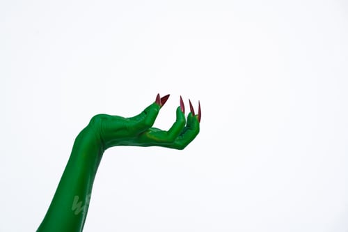 Preview: A green monster hand with long nails, isolated against a dark background, evokes horror and fear