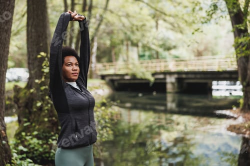 Preview: Black Woman Stretching Before Running Neat The River In Nature