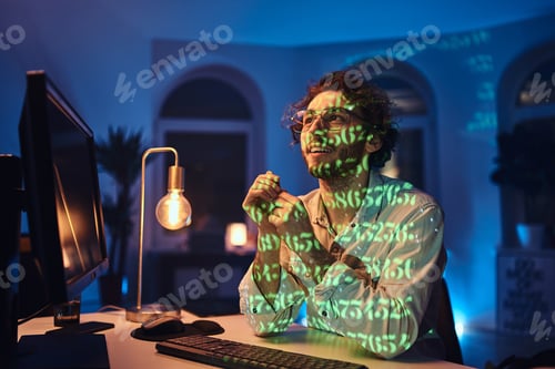 Preview: Caucasian freelancer with glasses and computer works in dark office