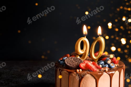 Preview: Chocolate birthday cake with berries, cookies and number ninety golden candles on black background