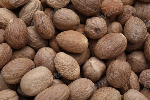 Preview: Heap of nutmeg seeds as background, top view