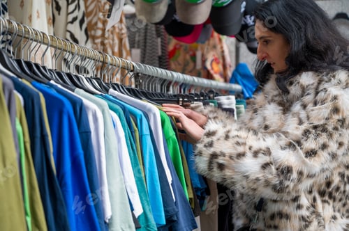 Preview: A woman choosing vintage clothes in a shop