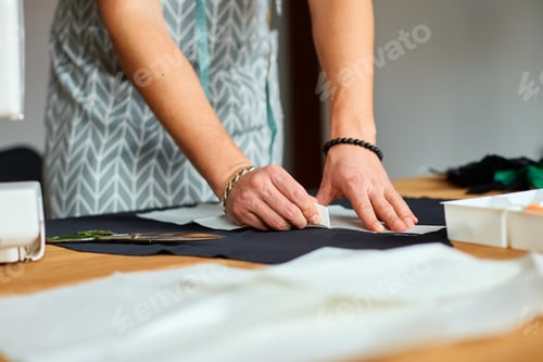 Preview: Man dressmaker making sewing patterns, male tailor working with sewing pattern in atelier