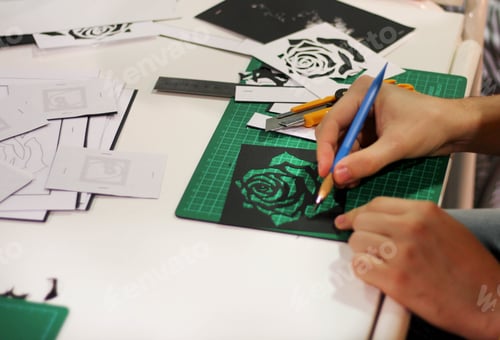 Preview: Hands cutting rose of paper on the paper cutting board