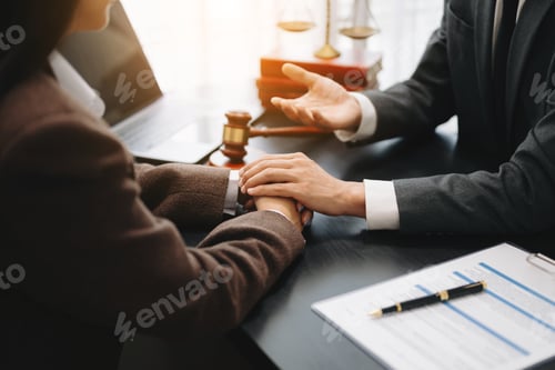 Preview: Business people compassionately holding hands and discussing contract papers with laptop