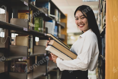 Preview: Young Asian women are searching for books and reading books on the tables and aisles of the college