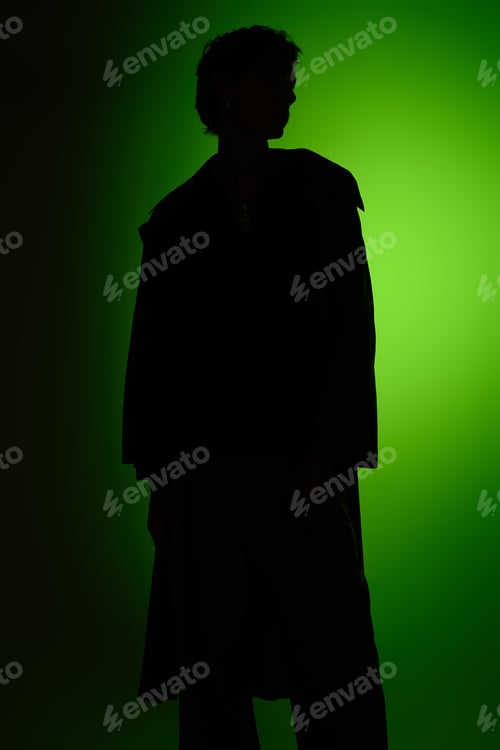 Preview: Handsome young man in stylish attire against a vibrant green backdrop