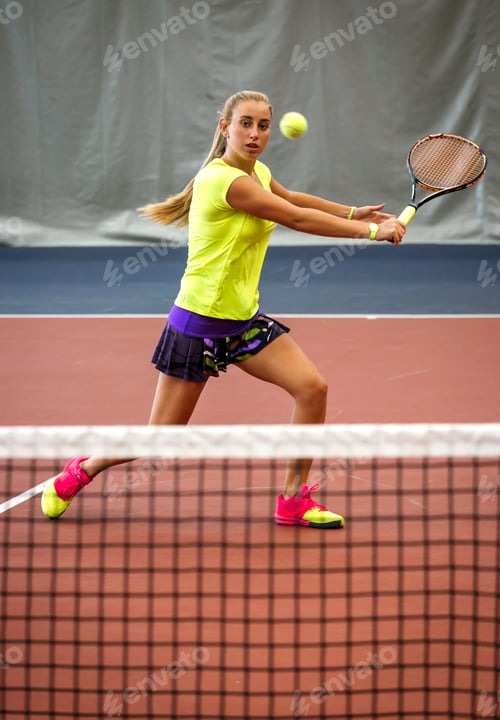 Preview: Young woman playing tennis in an indoor tennis center