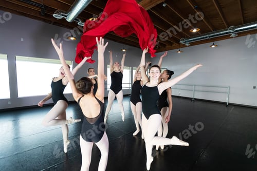 Preview: Group of young ballet dancers playing and having fun in dance studio with colorful fabric