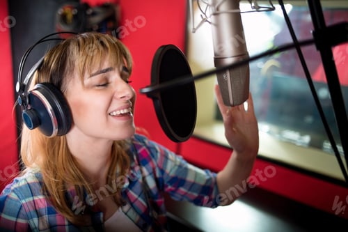 Preview: Female with microphone recording a voice for dubbing in music studio