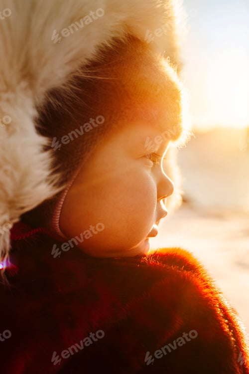 Preview: A child wrapped in warmth as the golden hour blankets them in soft light