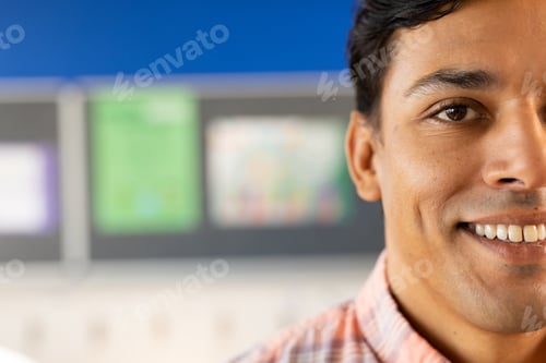 Preview: Half portrait of happy biracial male teacher with in elementary school classroom with copy space