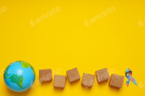 Preview: Ribbon with multi-colored puzzle pieces, cubes and a model of the planet Earth on a light background