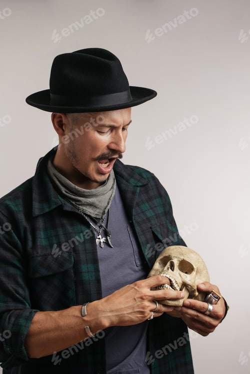 Preview: Stylish man with mustache wearing hat and holding scull posing indoors