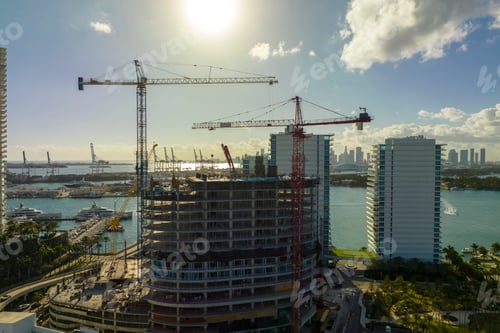 Preview: Tower lifting cranes at high residential apartment building construction site.
