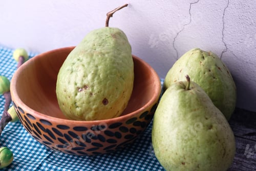Preview: Fresh and Juicy Green Pears Placed in a Bowl Set Against a Beautiful Rustic Background