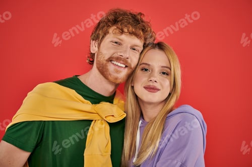 Preview: portrait of young couple looking at camera on coral background, vibrant colors, stylish outfits,