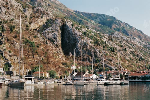 Preview: Sailboats stand at the pier at the foot of the rocky mountains