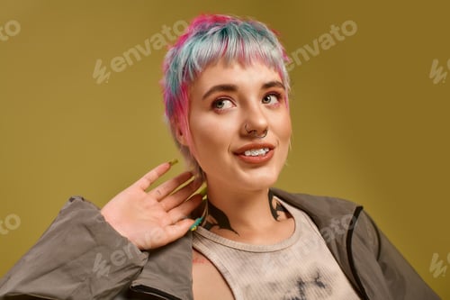 Preview: Vibrant young woman with colorful hair poses elegantly in a bright studio setting