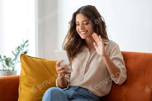 Preview: Cheerful Woman Waving During Video Call At Home
