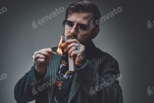 Preview: Styled and bearded hipster person with cuban cigar in gray background