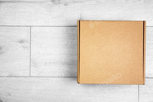 Preview: Closed cardboard box on wooden floor