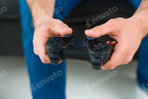 Preview: partial view of man playing video game at home
