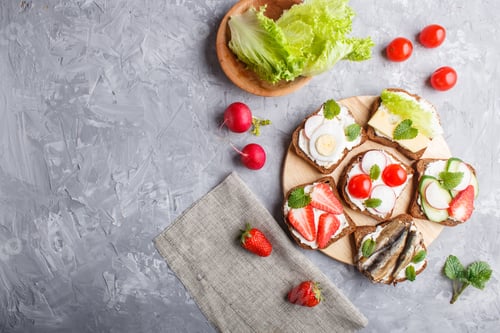 Preview: Set of different sandwiches with cheese, radish, lettuce, strawberry, sprats, tomatoes and cucumber