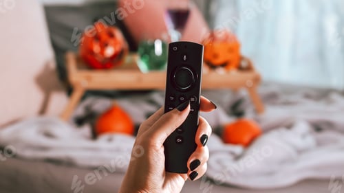 Preview: Woman holding remote controller on Halloween background