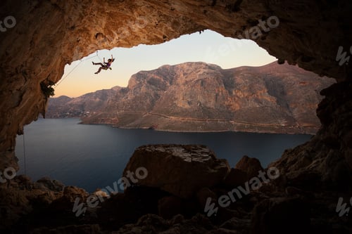 Preview: Female rock climber falling of cliff in big cave