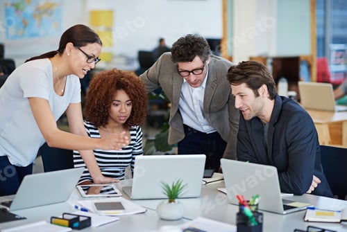Preview: Streamlining their online site. Cropped shot of business people working on laptops around a table.
