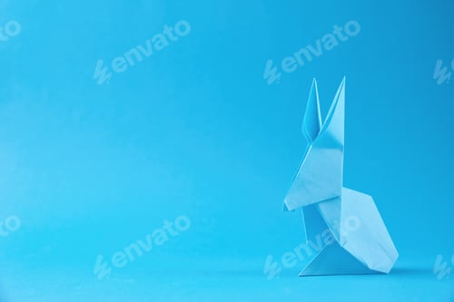 Preview: Paper origami Esater rabbit on a blue background. Easter celebration concept