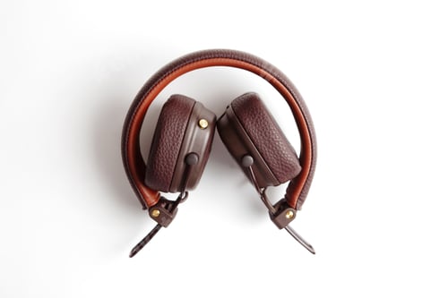 Preview: Modern brown leather wireless folded headphones isolated on white