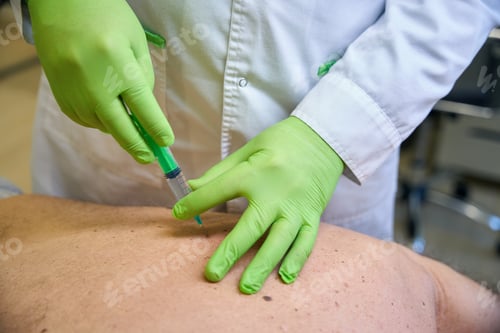 Preview: Doctor giving an injection to patient in a hospital bed